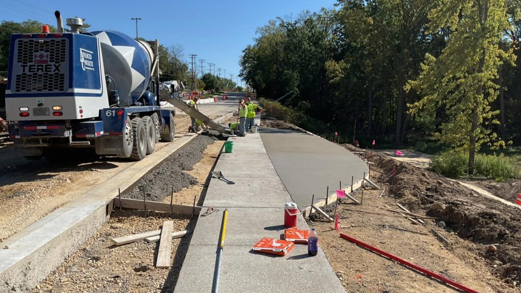Concrete truck pouring fresh sidewalk